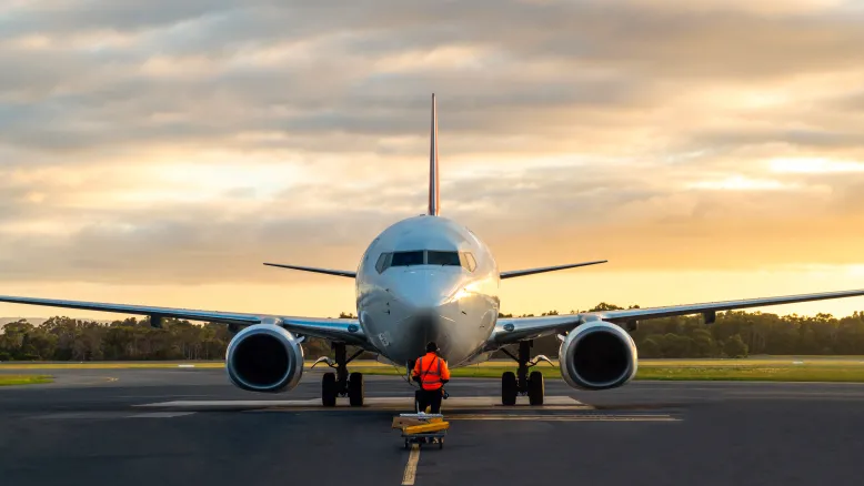Sunset view of airplane on airport runway under dramatic sky in Hobart, Tasmania.