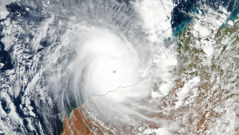 Satellite photo of the north-west Australian coast. The eye of Tropical Cyclone Isla is north of Port Hedland, in the middle of a swirling mass of cloud. Beyond this, fragments of cloud scatter over the ocean and Australian continent.