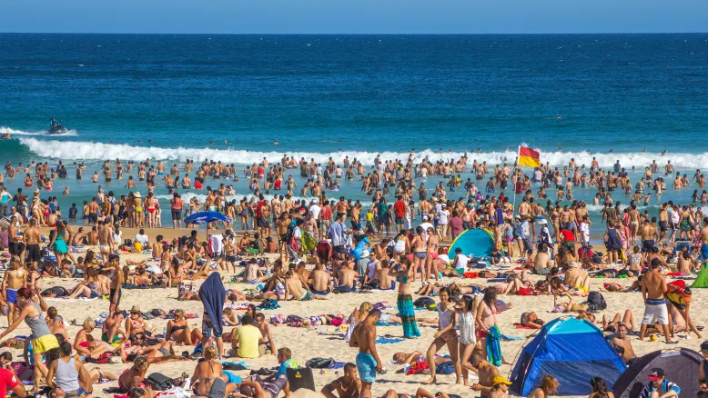 Very crowded Bondi Beach in Sydney on a hot sunny day.
