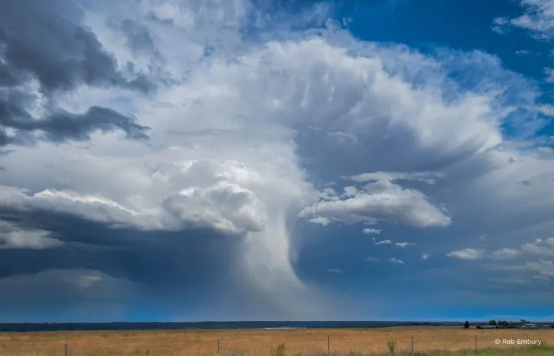 Core of a major thunderstorm passes over the ocean in the far distance.