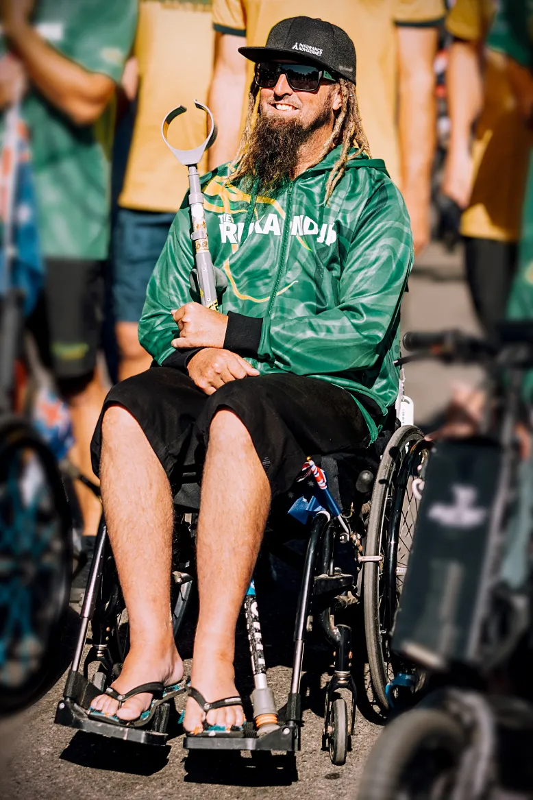 Cliff Gralton sits in a wheelchair in an outdoor area.