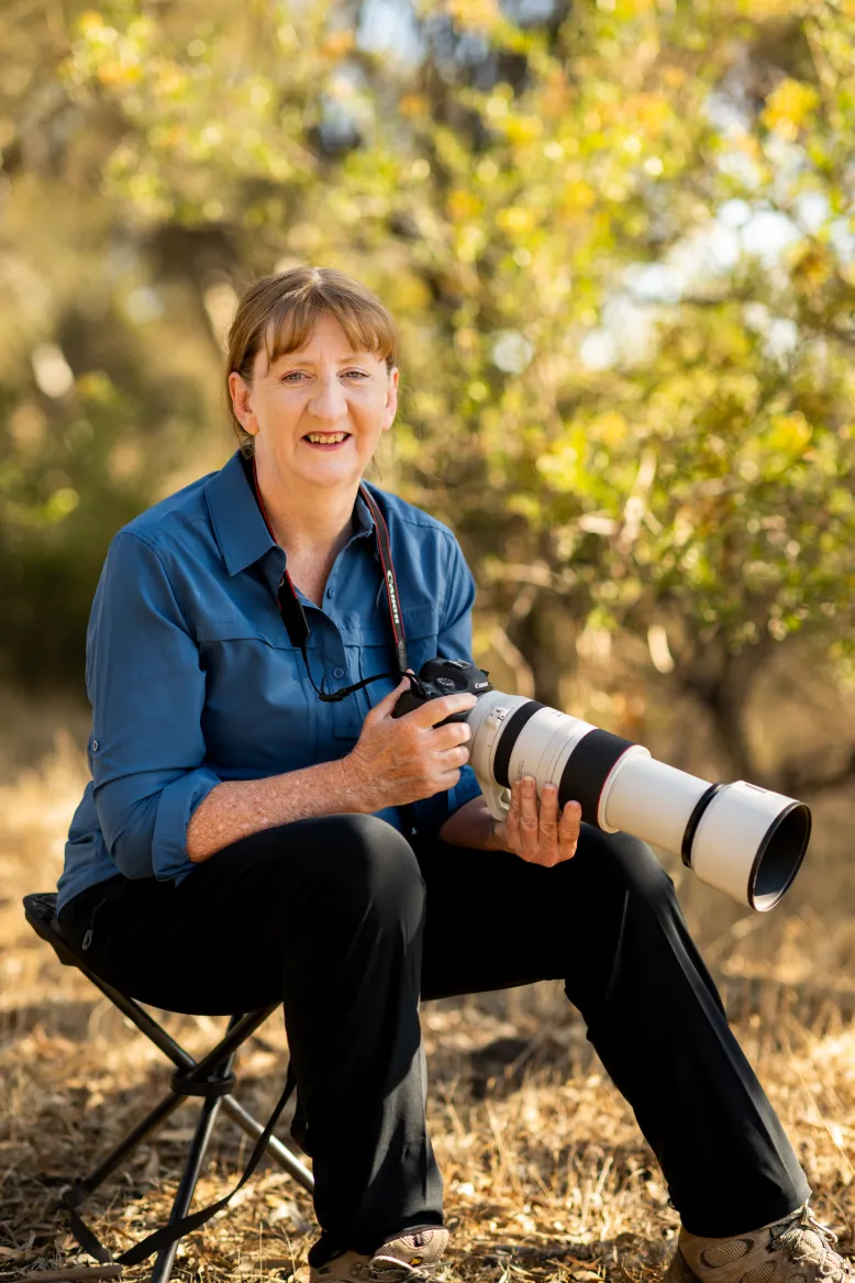 Woman holding a camera with a long lense.