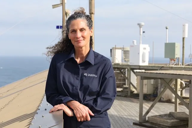 Bureau of Meteorology station manager Sarah Prior stands outside in front of measuring equipment.