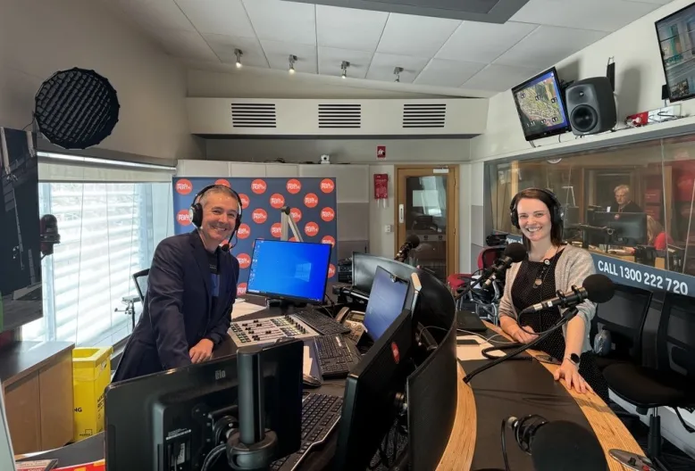 Meteorologist Jessica Lingard with former ABC WA Afternoons host Michael Tetlow smiling at the camera in a radio studio.