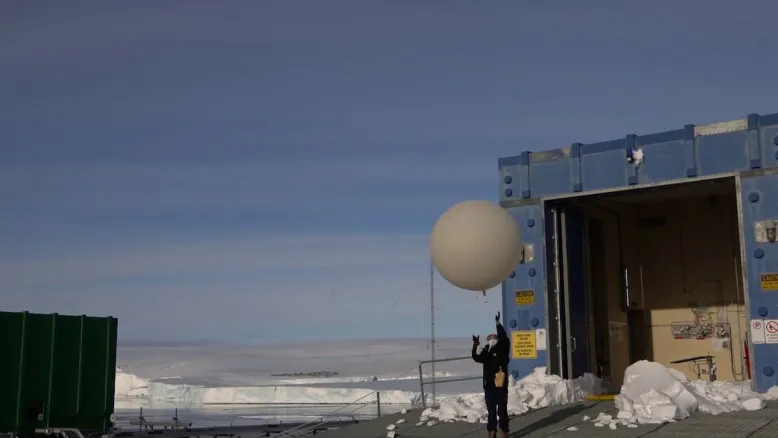 Person releasing a weather balloon in Antarctica.