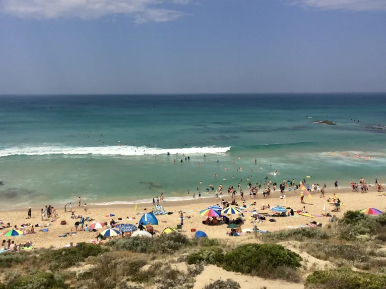 Image of a busy beach on a hot summer day.
