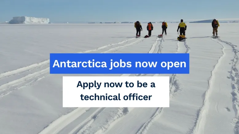Group of expeditioners travelling across a snow-covered Antarctic landscape, leaving tracks in the snow. Icebergs are visible in the distance. Overlaid text reads: Antarctica jobs now open. Apply now to be a technical officer.